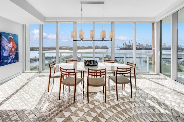 sunroom with a water view and an inviting chandelier