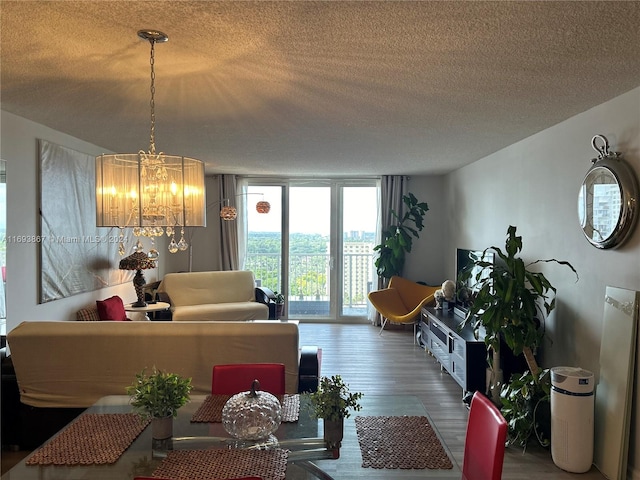 dining room with wood-type flooring, a textured ceiling, floor to ceiling windows, and a notable chandelier