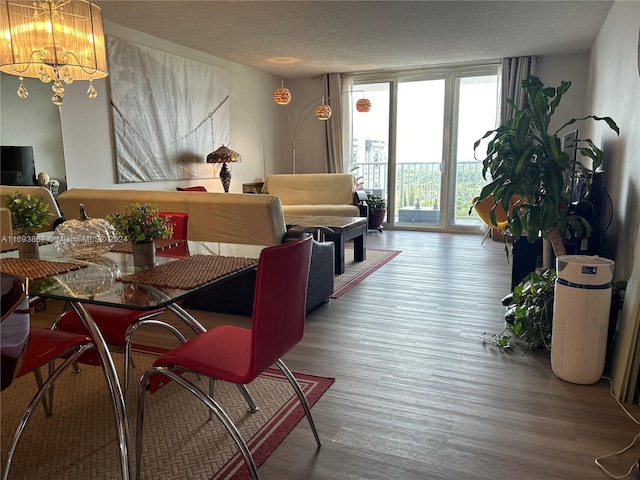 dining space with hardwood / wood-style floors, expansive windows, a textured ceiling, and an inviting chandelier