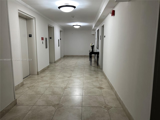 hallway featuring elevator, crown molding, and light tile patterned floors