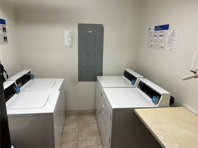 washroom with washing machine and clothes dryer, electric panel, and light tile patterned flooring