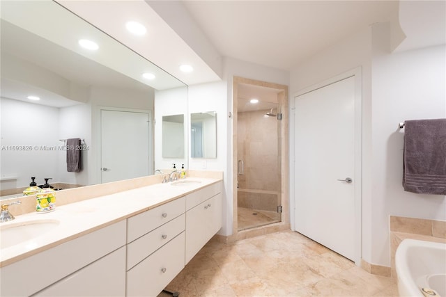 bathroom featuring vanity and independent shower and bath