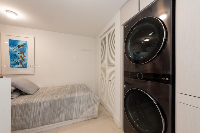 bedroom with stacked washer / dryer and a closet