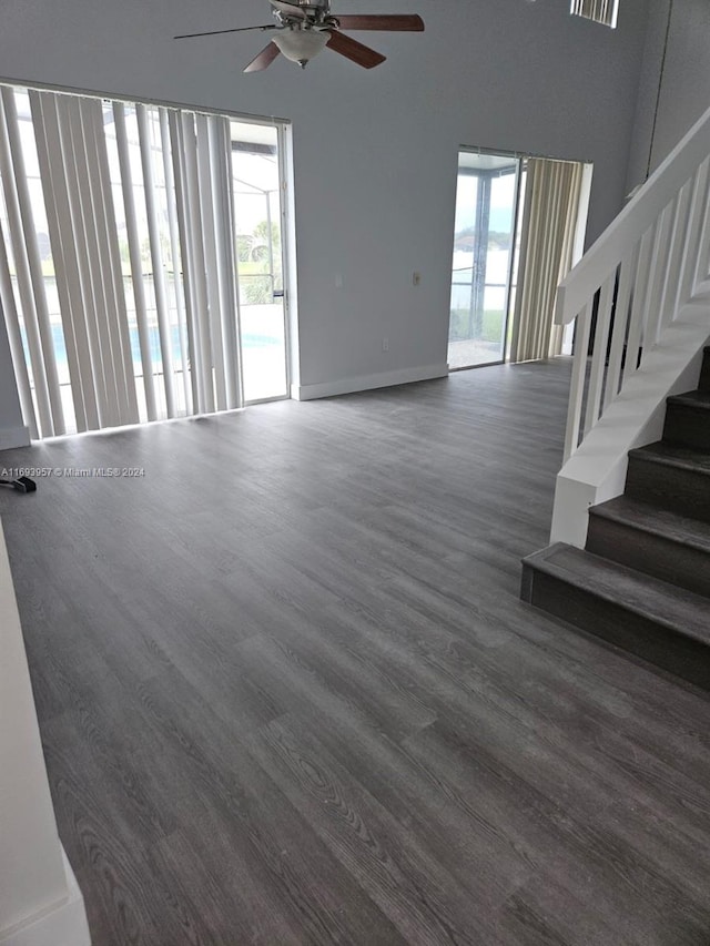 unfurnished living room featuring ceiling fan and dark hardwood / wood-style flooring