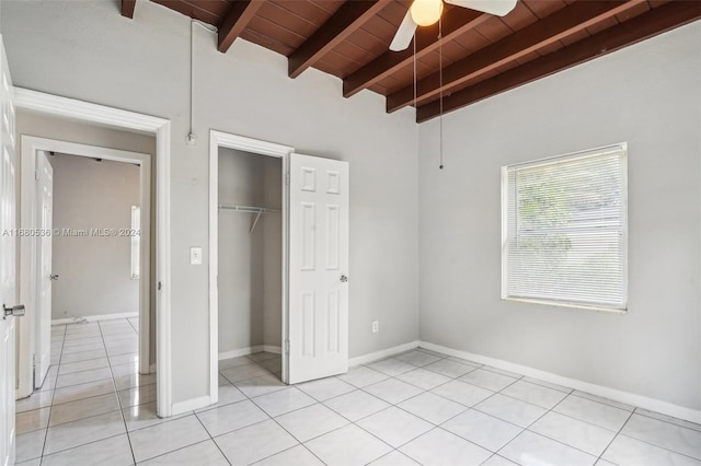 unfurnished bedroom featuring beam ceiling, ceiling fan, wooden ceiling, a closet, and light tile patterned floors