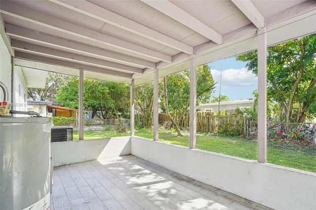 unfurnished sunroom with beamed ceiling and water heater