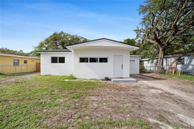 rear view of house featuring a yard