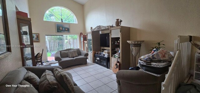 tiled living room featuring high vaulted ceiling