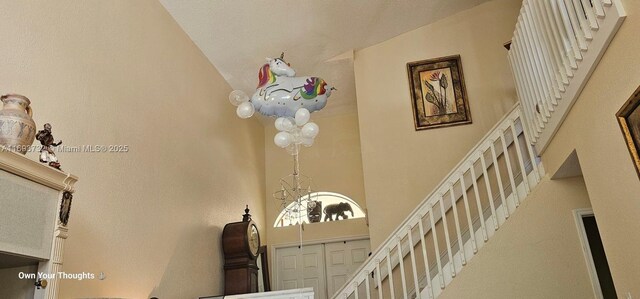 staircase featuring a chandelier and a high ceiling