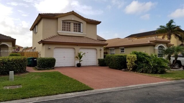 view of front of house with a garage and a front lawn