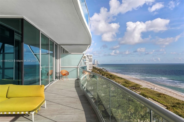 balcony featuring a water view and a view of the beach