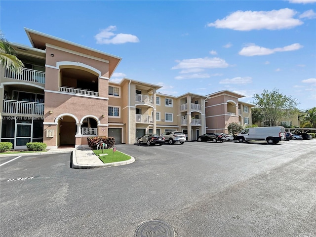 6458 Emerald Dunes Dr Unit 303, West Palm Beach, FL 33411 - view of apartment building / complex featuring uncovered parking