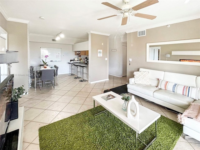 living room with ceiling fan, light tile patterned flooring, and ornamental molding