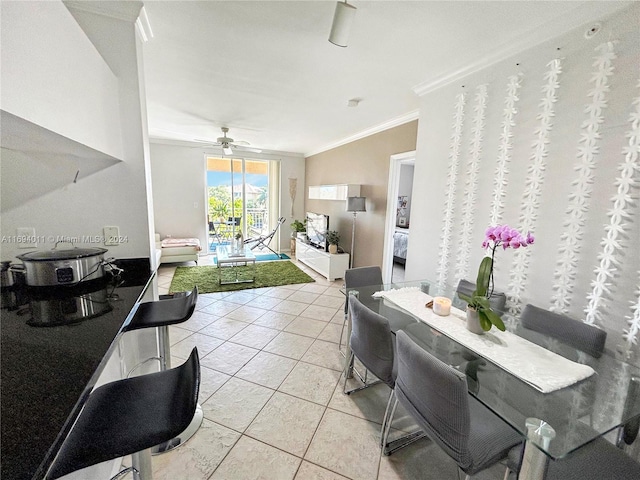 dining space with ceiling fan, light tile patterned floors, and ornamental molding