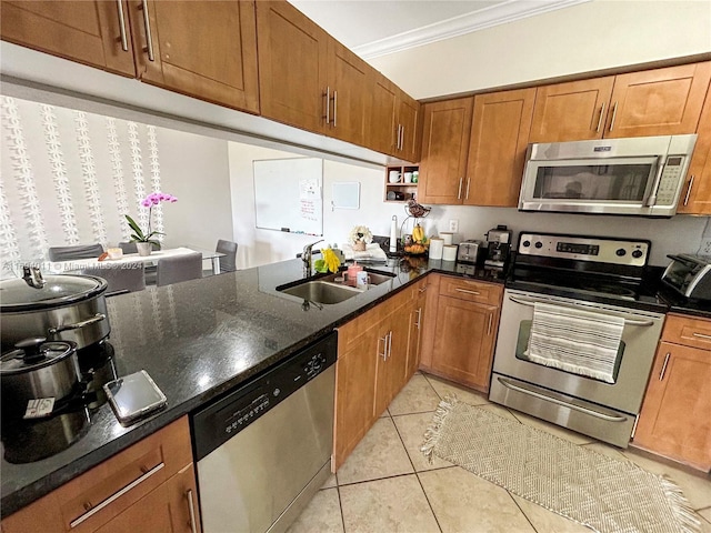 kitchen featuring sink, dark stone countertops, appliances with stainless steel finishes, light tile patterned flooring, and ornamental molding