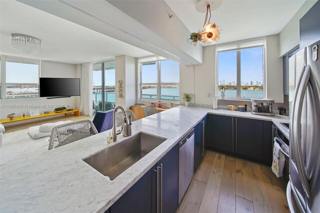 kitchen featuring a wealth of natural light, decorative light fixtures, dark hardwood / wood-style floors, and sink