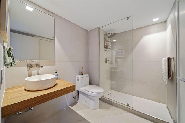 bathroom featuring toilet, sink, tile walls, and a tile shower