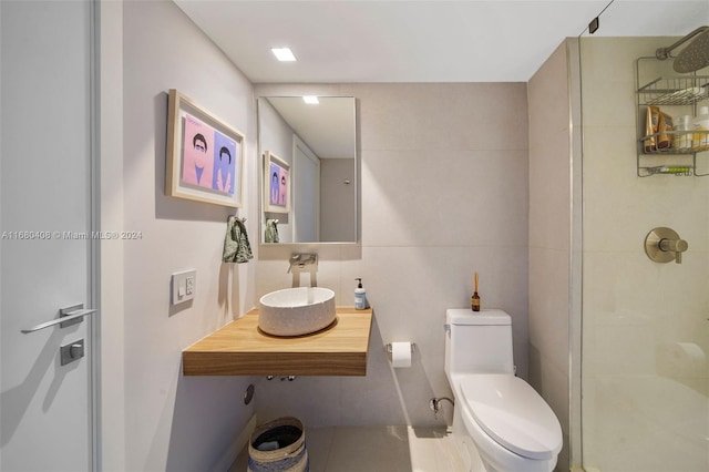 bathroom featuring tile patterned floors, walk in shower, sink, tile walls, and toilet