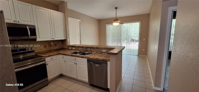 kitchen with ceiling fan, sink, stainless steel appliances, kitchen peninsula, and white cabinets