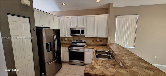 kitchen featuring white cabinets, sink, stainless steel appliances, and tasteful backsplash