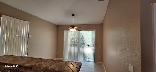 unfurnished dining area with ceiling fan and light tile patterned floors