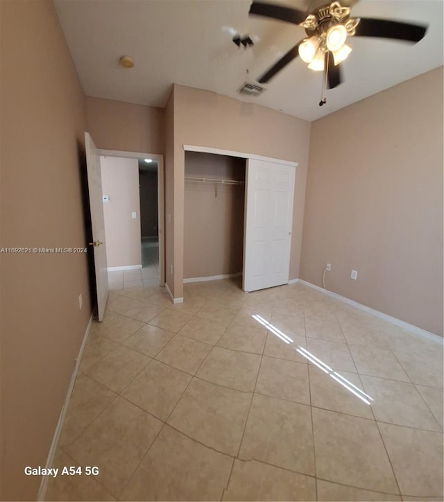 unfurnished bedroom with ceiling fan, light tile patterned floors, and a closet