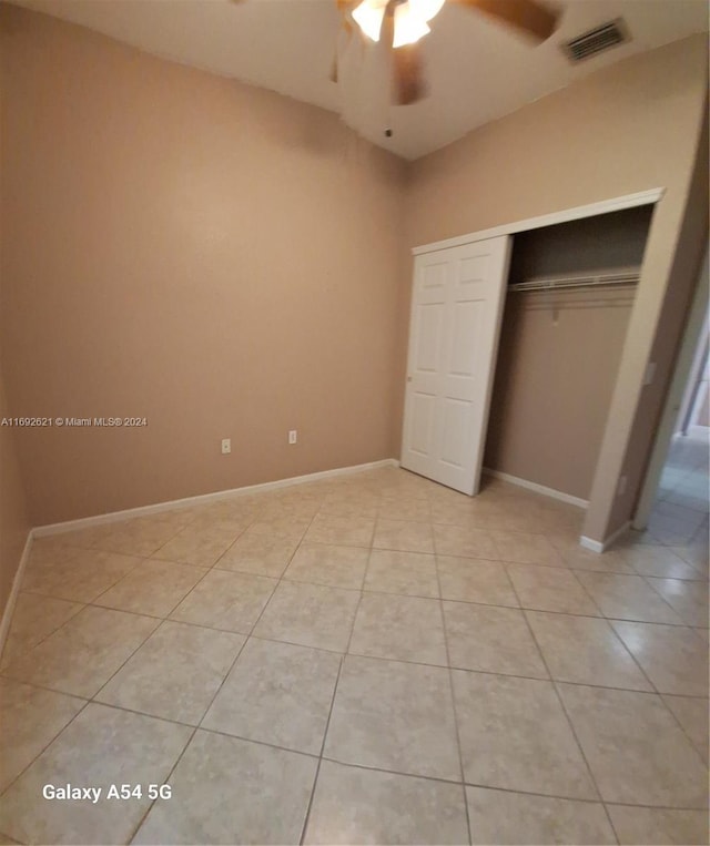 unfurnished bedroom with ceiling fan, a closet, and light tile patterned flooring