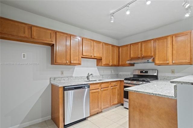 kitchen with light stone countertops, sink, light tile patterned floors, and stainless steel appliances