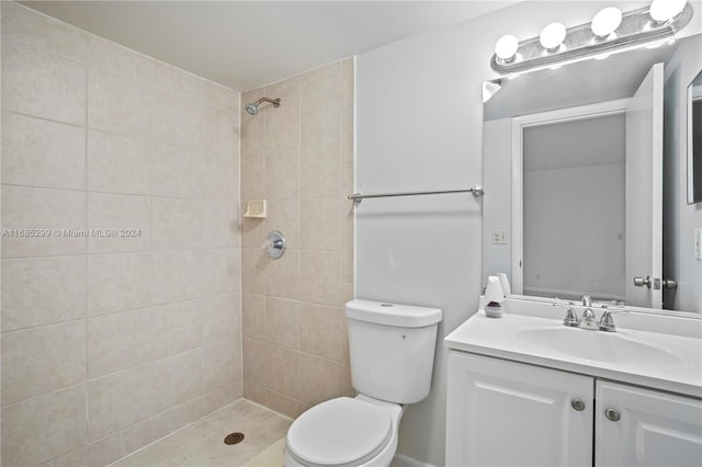 bathroom with tiled shower, vanity, and toilet