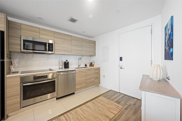 121 NE 34th St Unit 3014, Miami, FL 33137 - kitchen featuring stainless steel appliances, a sink, light countertops, and light wood-type flooring