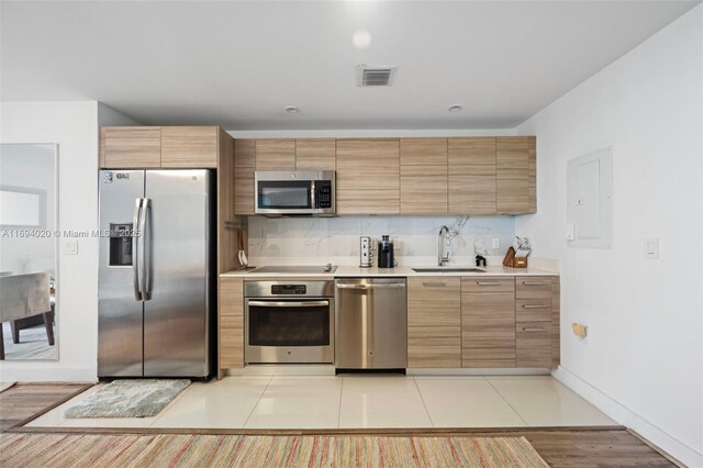 121 NE 34th St Unit 3014, Miami, FL 33137 - kitchen with stainless steel appliances, a sink, light countertops, baseboards, and backsplash