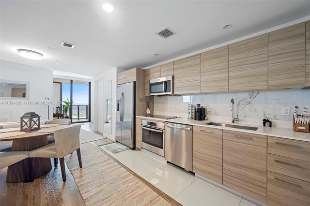 121 NE 34th St Unit 3014, Miami, FL 33137 - kitchen with stainless steel appliances, a sink, tasteful backsplash, light countertops, and modern cabinets