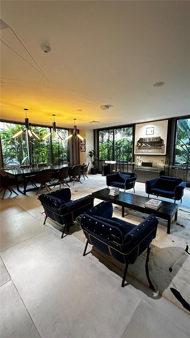 living room featuring a chandelier, a wall of windows, and plenty of natural light