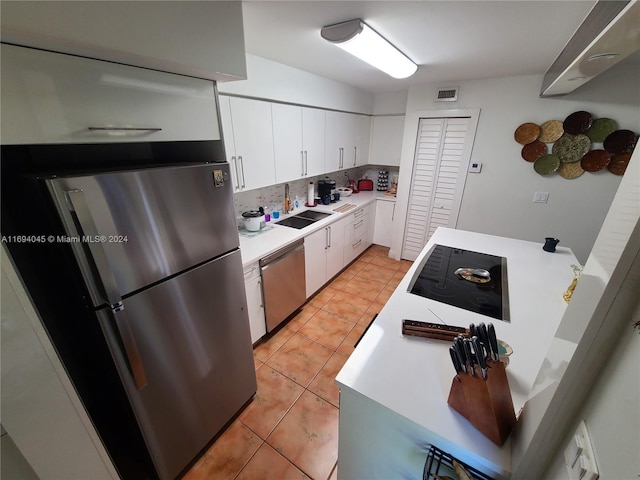 kitchen with sink, light tile patterned floors, tasteful backsplash, white cabinetry, and stainless steel appliances