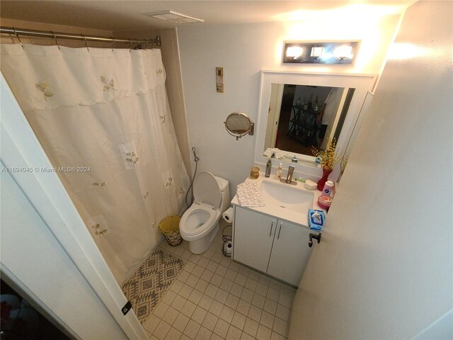 bathroom featuring tile patterned floors, vanity, curtained shower, and toilet