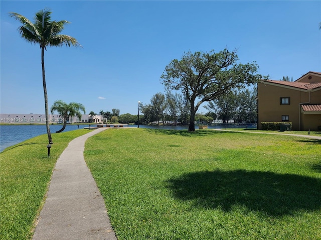 surrounding community featuring a water view and a lawn