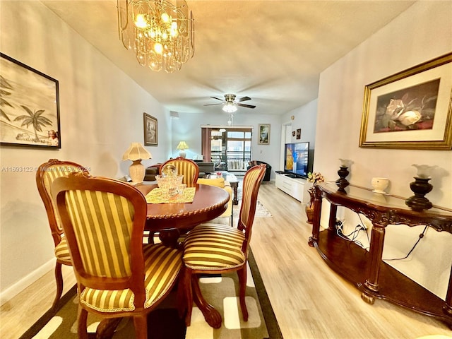 dining area featuring ceiling fan with notable chandelier and light wood-type flooring