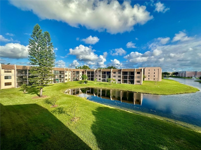 surrounding community with a water view and a yard