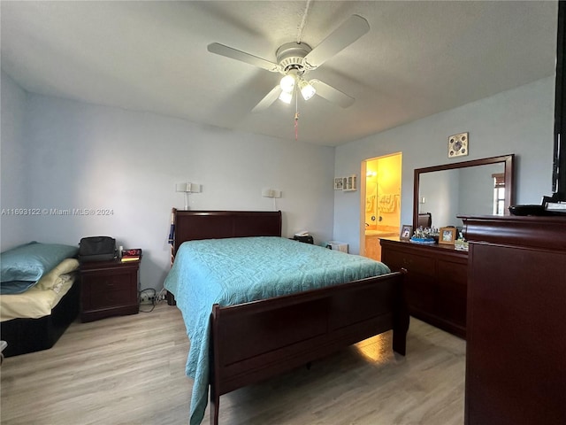 bedroom featuring light wood-type flooring, ensuite bathroom, and ceiling fan