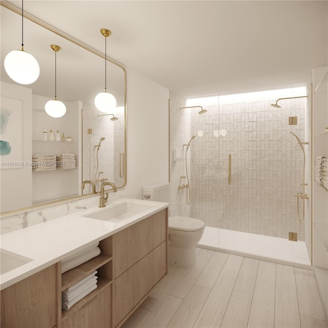 bathroom featuring a shower with door, vanity, and toilet