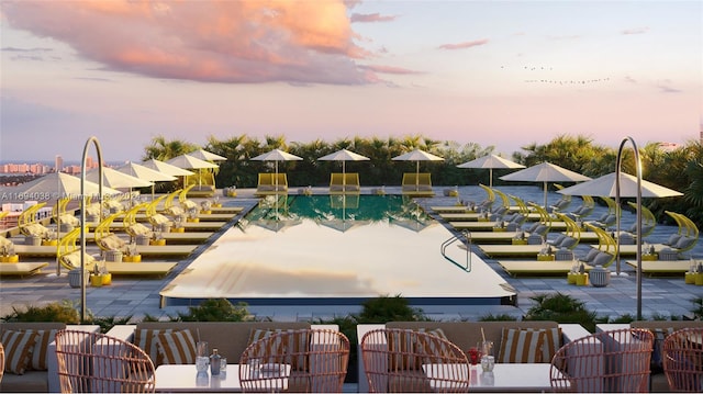 pool at dusk with a patio area