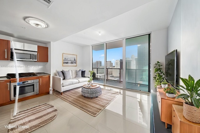 living room featuring light tile patterned flooring and floor to ceiling windows