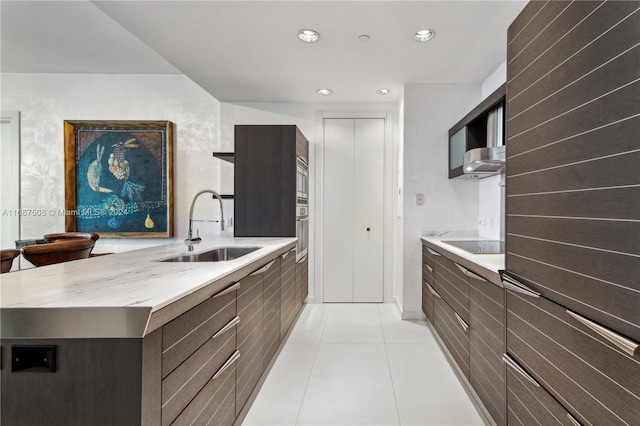 kitchen featuring black electric stovetop, oven, ventilation hood, sink, and light tile patterned flooring