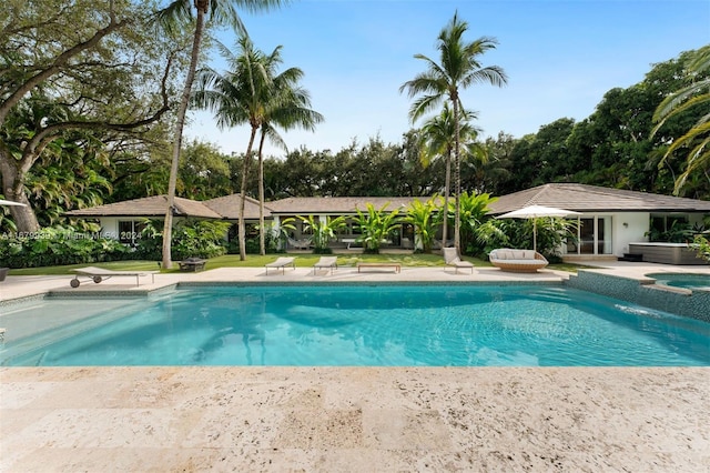 view of swimming pool with an outdoor hot tub