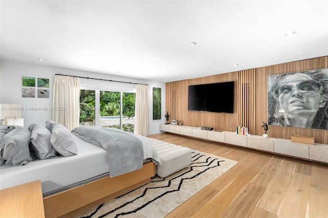 bedroom with hardwood / wood-style floors and access to outside