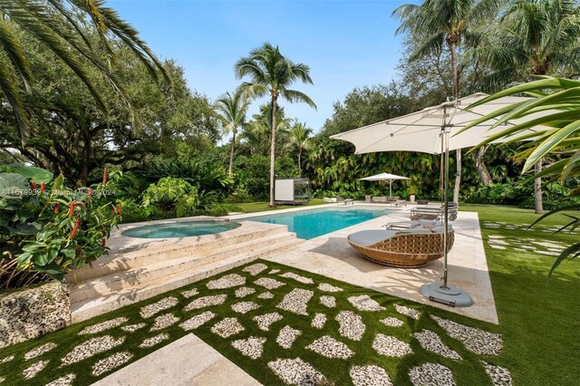 view of swimming pool with an in ground hot tub, a patio area, a yard, and a storage shed