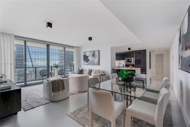 dining space featuring floor to ceiling windows and sink