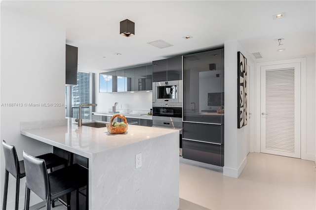 kitchen featuring a kitchen breakfast bar, kitchen peninsula, and sink