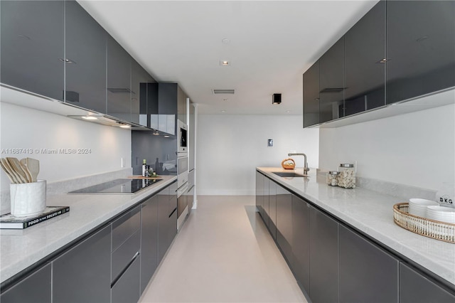 kitchen featuring black electric cooktop, sink, and oven