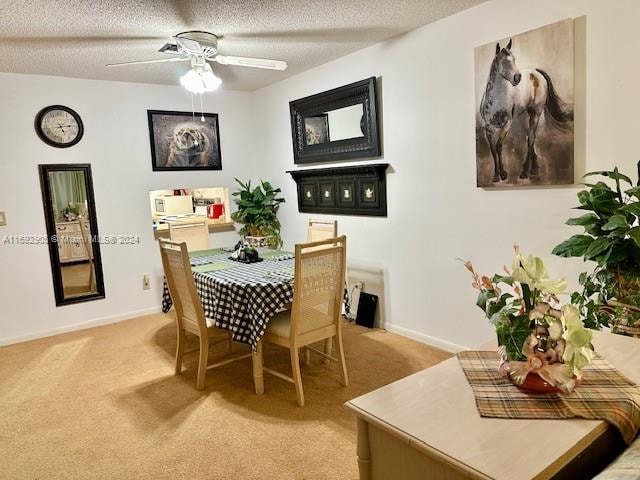 dining space with ceiling fan, a textured ceiling, and light carpet